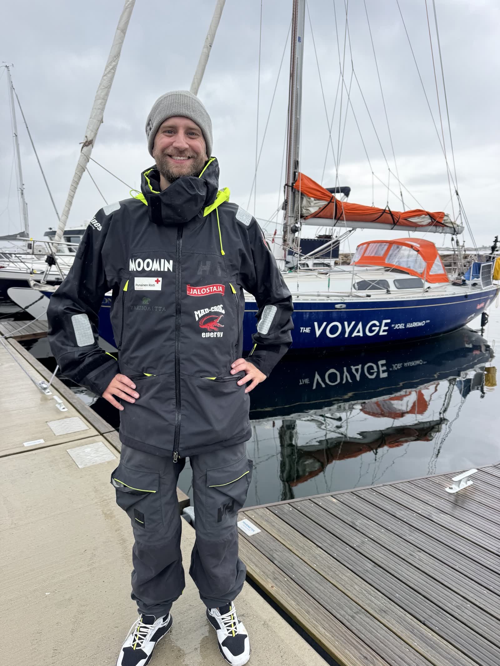 Joel Harkimo in sailing gear next to his boat
